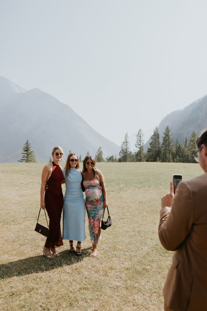 Guests posing together for a photo at a mountain wedding ceremony site with scenic views