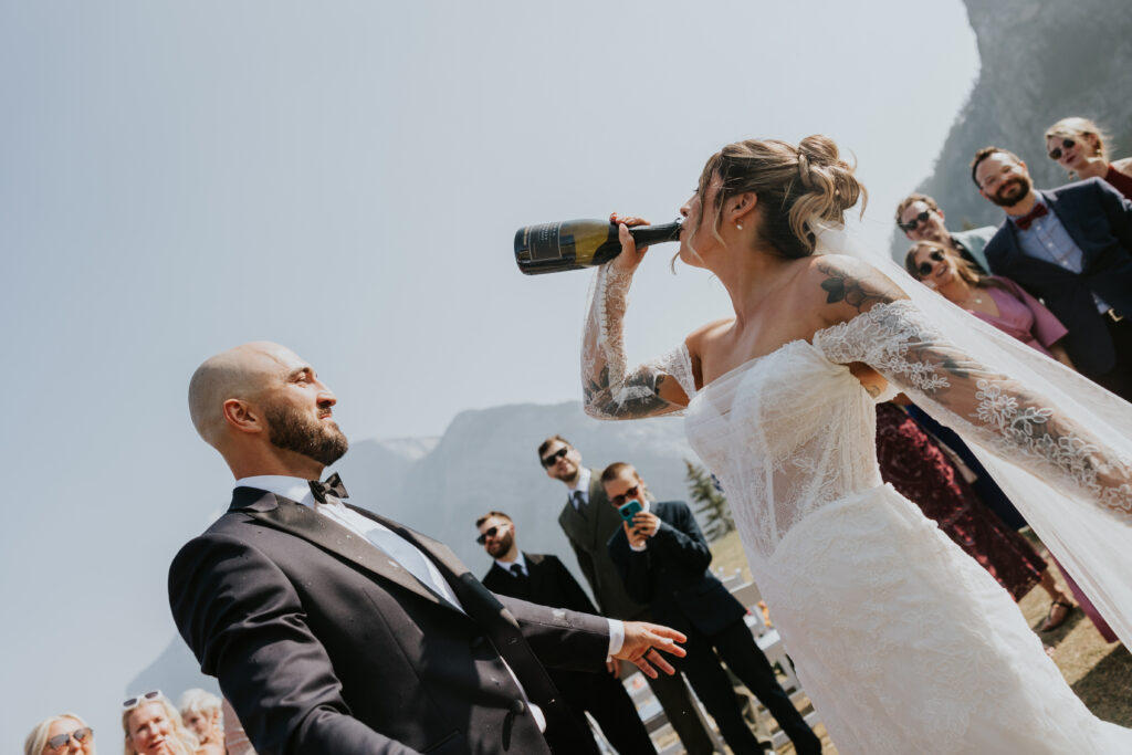 Large group of wedding guests gathered for a celebratory photo with Rocky Mountain scenery behind them