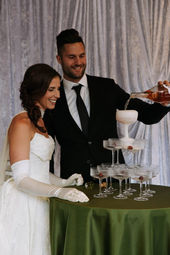 Close-up of wedding table centerpiece featuring green florals, anthuriums, hydrangeas, and classical sculpture detail